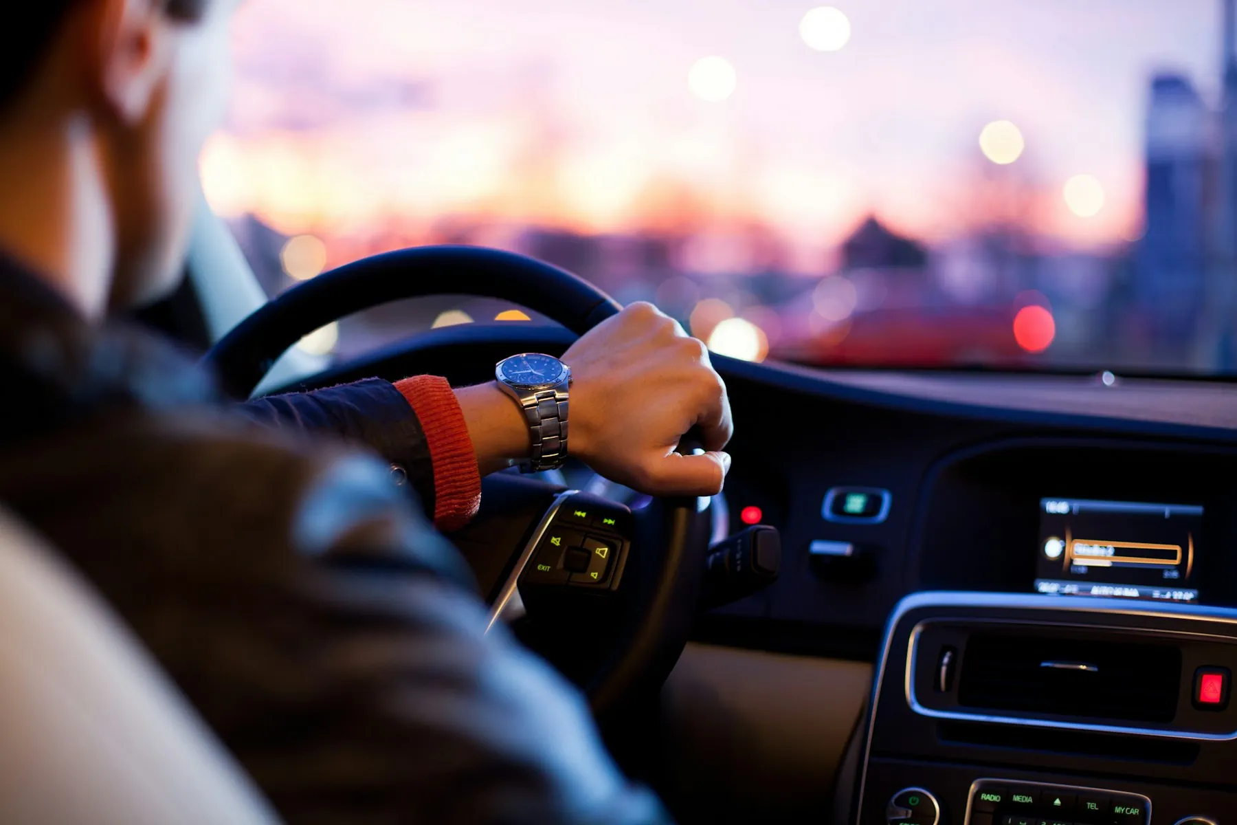 Driver behind the wheel on a Dubai road at dusk